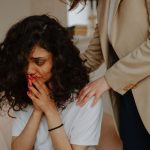 A young woman receiving comforting support in a counseling session.