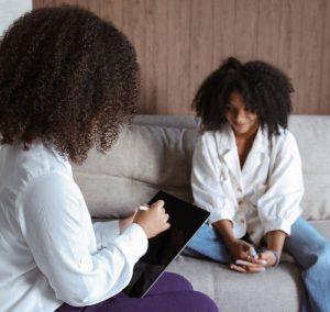 Two women in a psychotherapy session discussing mental health issues.